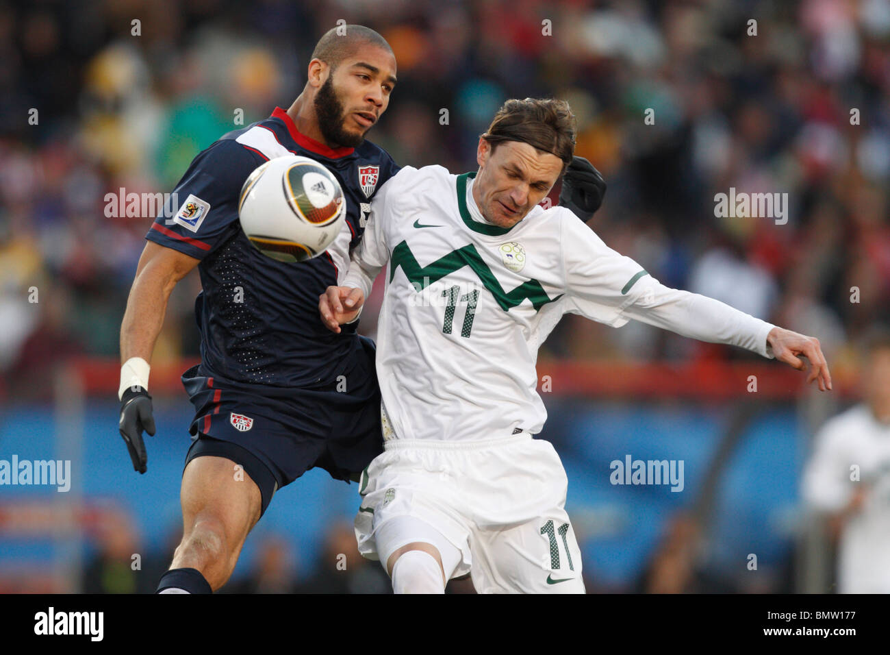 Oguchi Onyewu of the United States (l) and Milivoje Novakovic of Slovenia (r) clash  for the ball during a 2010 World Cup match Stock Photo