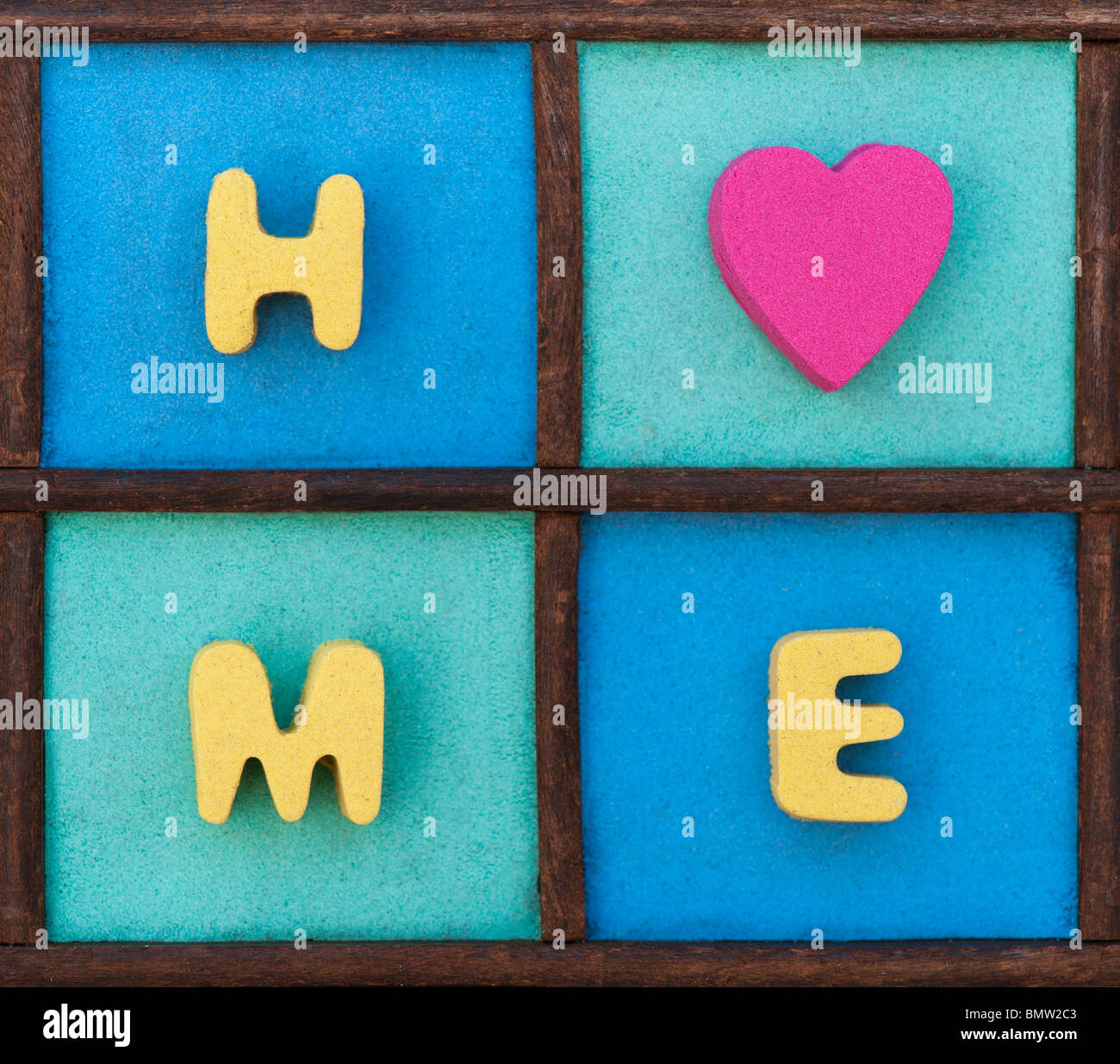 Multicoloured home and heart shape pattern in a wooden tray Stock Photo