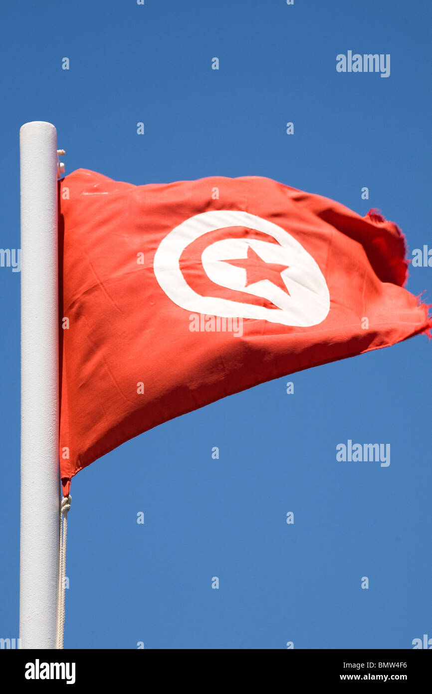 The flag of Tunisia flies against a blue sky Stock Photo Alamy