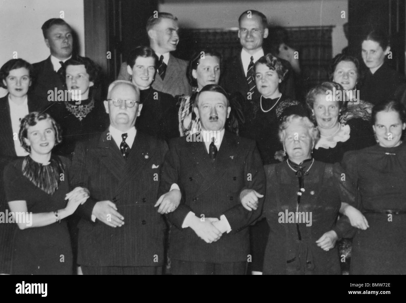 HITLER arm in arm with Nazi Party Treasurer Franz Xavier Schwarz and his wife while Eva Braun is at left Stock Photo