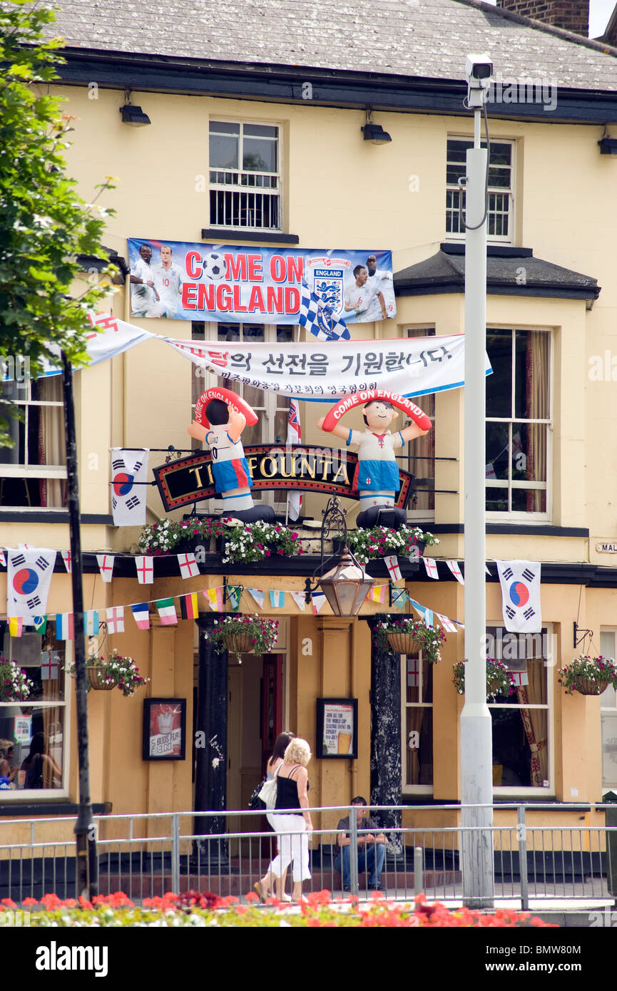 Pub front festooned with World Cup flags and inflatable football