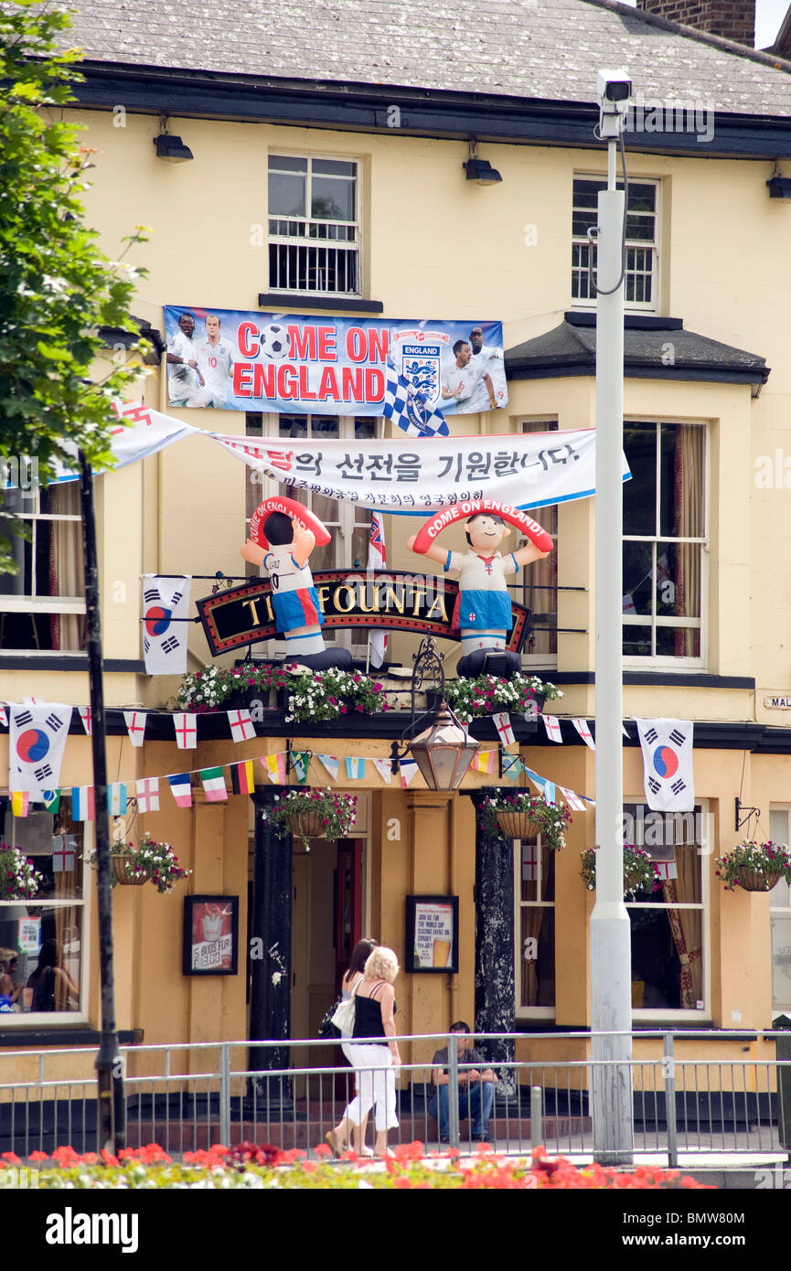 Pub front festooned with World Cup flags and inflatable football players, celebrating England and South Korea, New Malden London Stock Photo