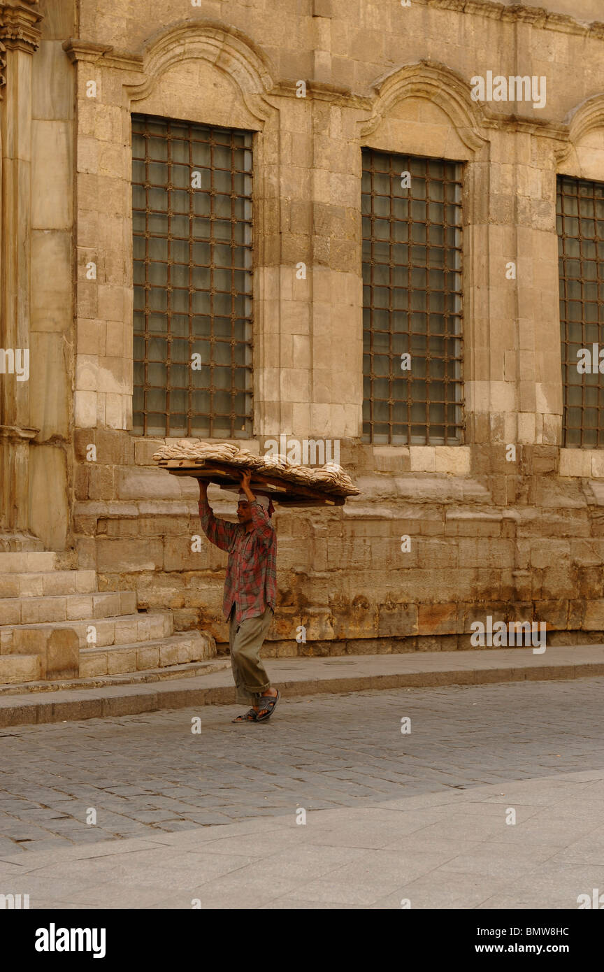 bread delivery man walking past one of the many mosques in islamic