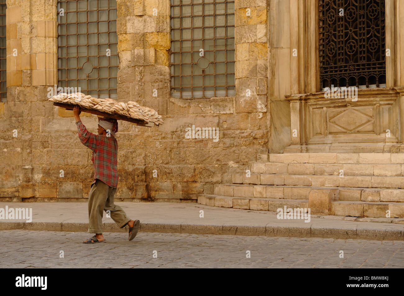 bread delivery man walking past one of the many mosques in islamic