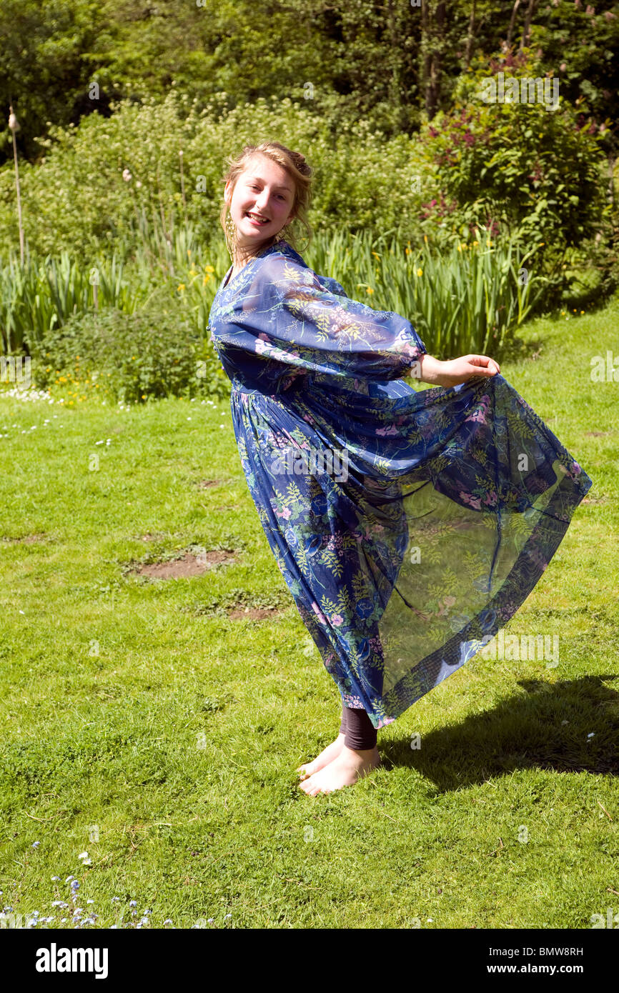 Teenage blonde girl wearing new dress in garden Stock Photo