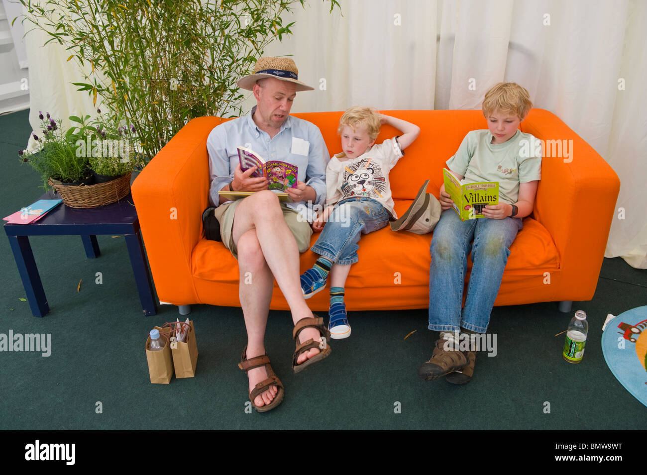 Adults reading to children in the reading corner in Hay Fever children's space at Hay Festival 2010 Hay on Wye Powys Wales UK Stock Photo