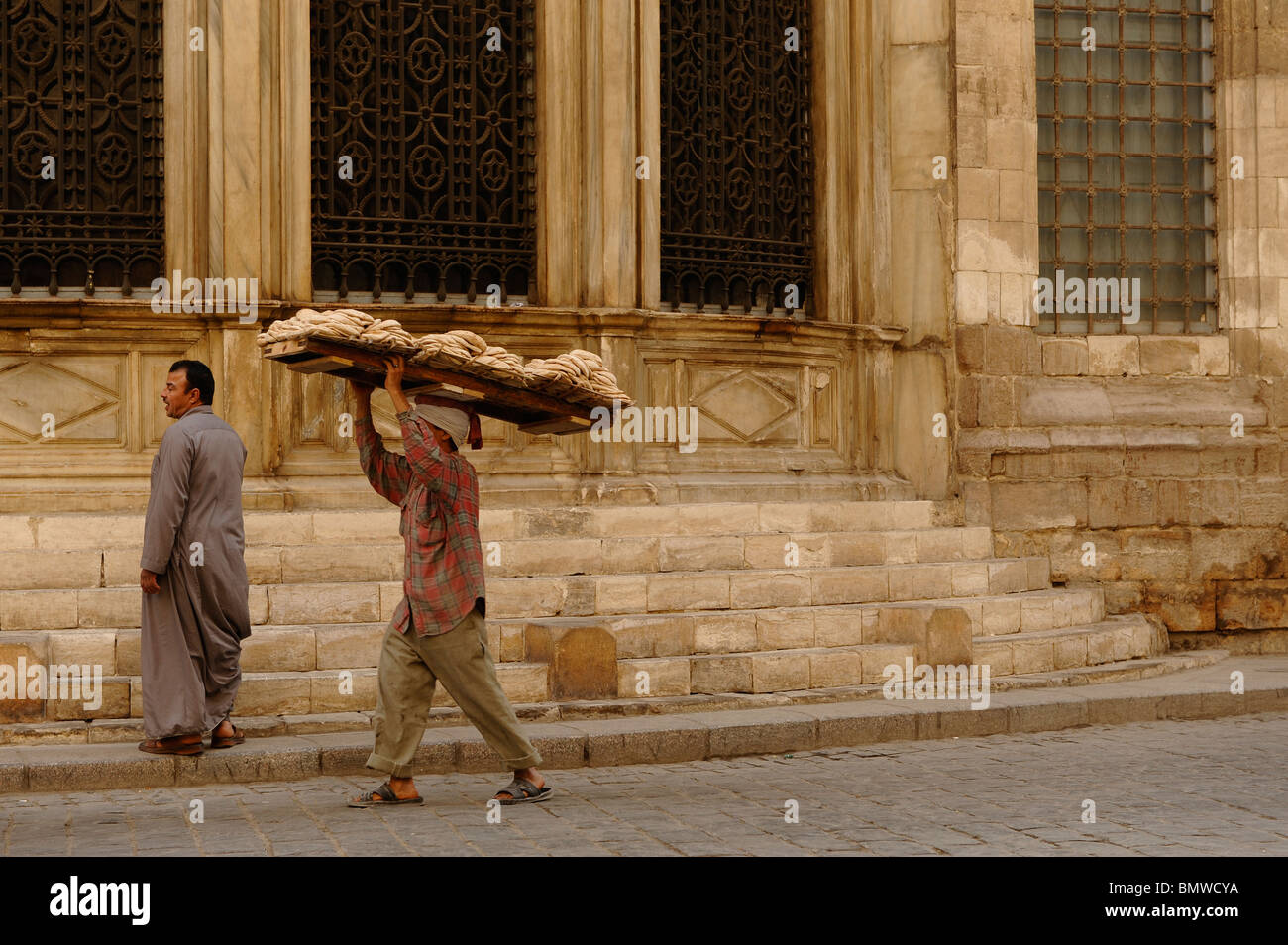 bread delivery man walking past one of the many mosques in islamic