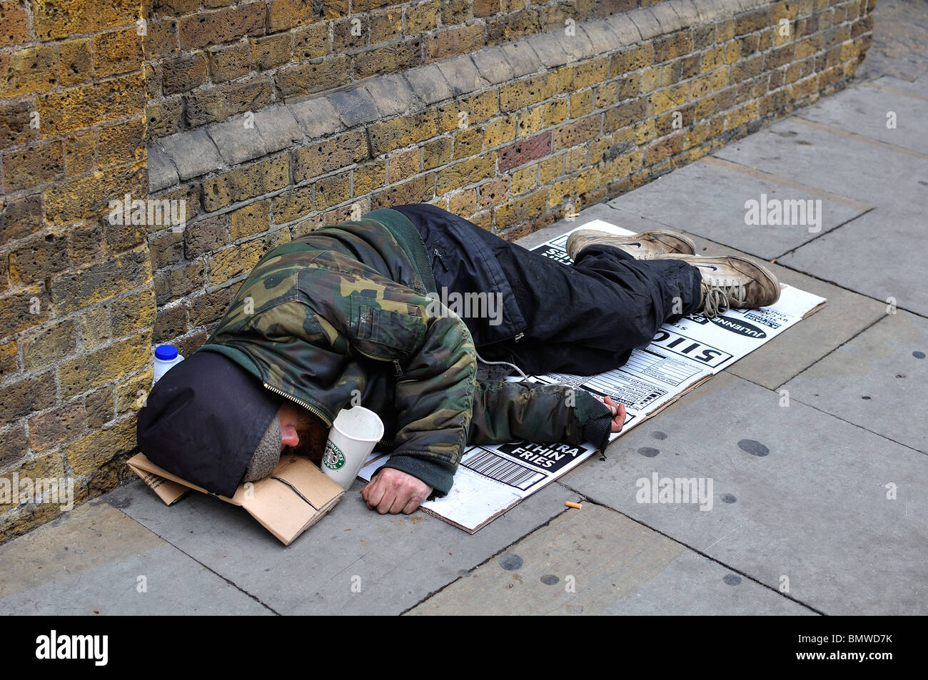 homeless-man-sleeping-on-pavement-in-london-BMWD7K.jpg