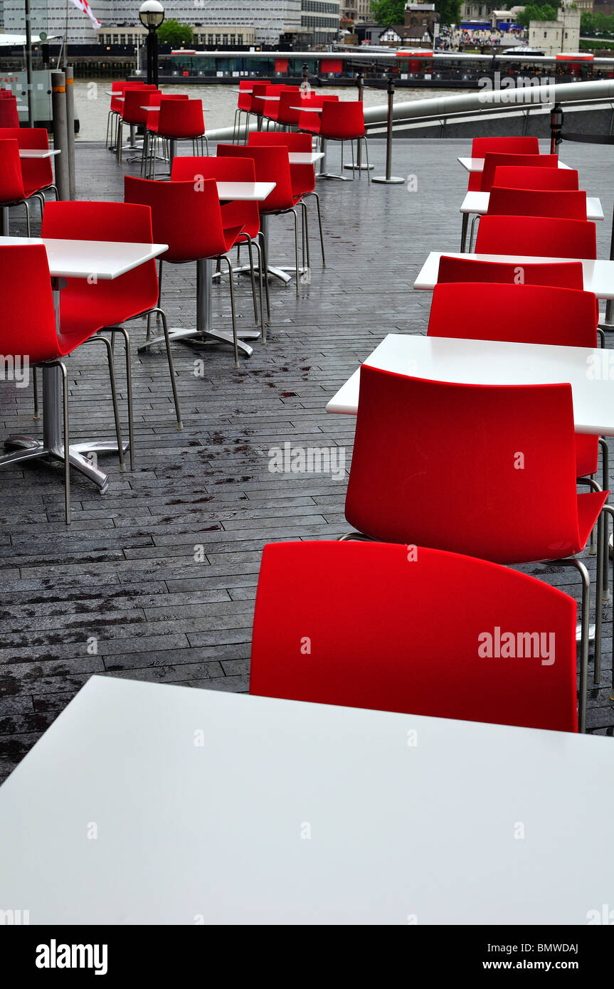 White tables with red chairs outside a restaurant in London Stock Photo