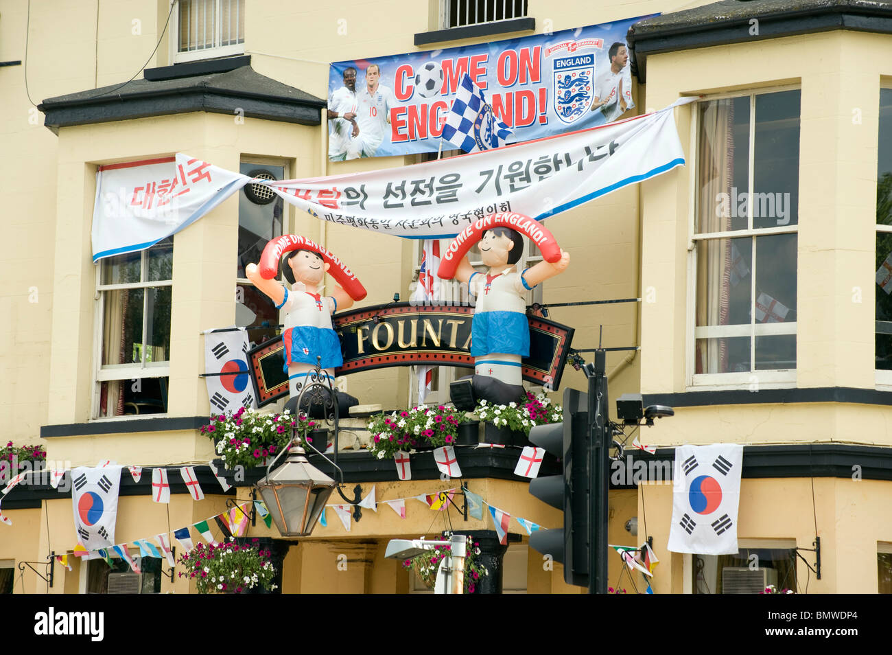 Pub front festooned with World Cup flags and inflatable football