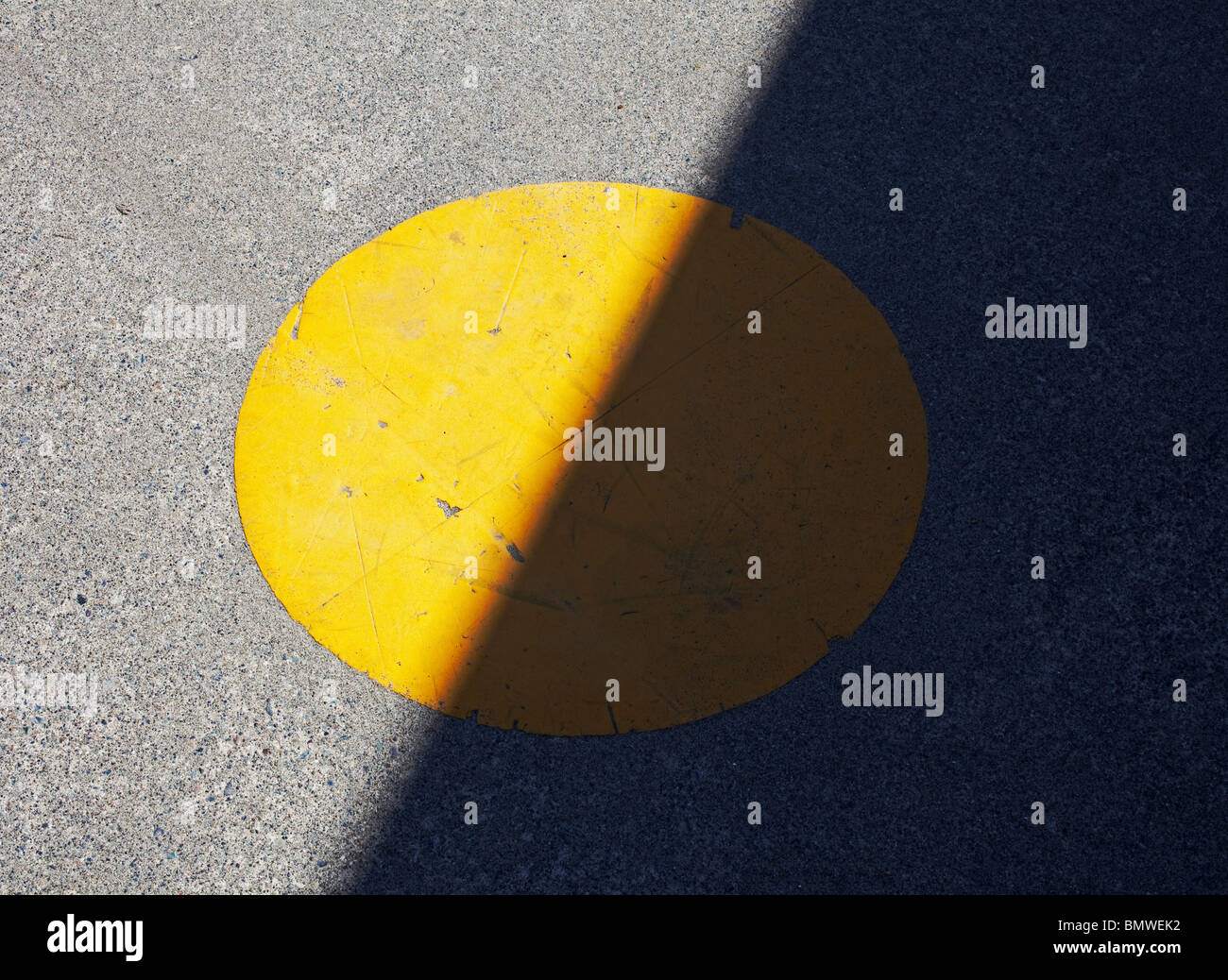 painted yellow spot on sidewalk in half shadow Stock Photo Alamy