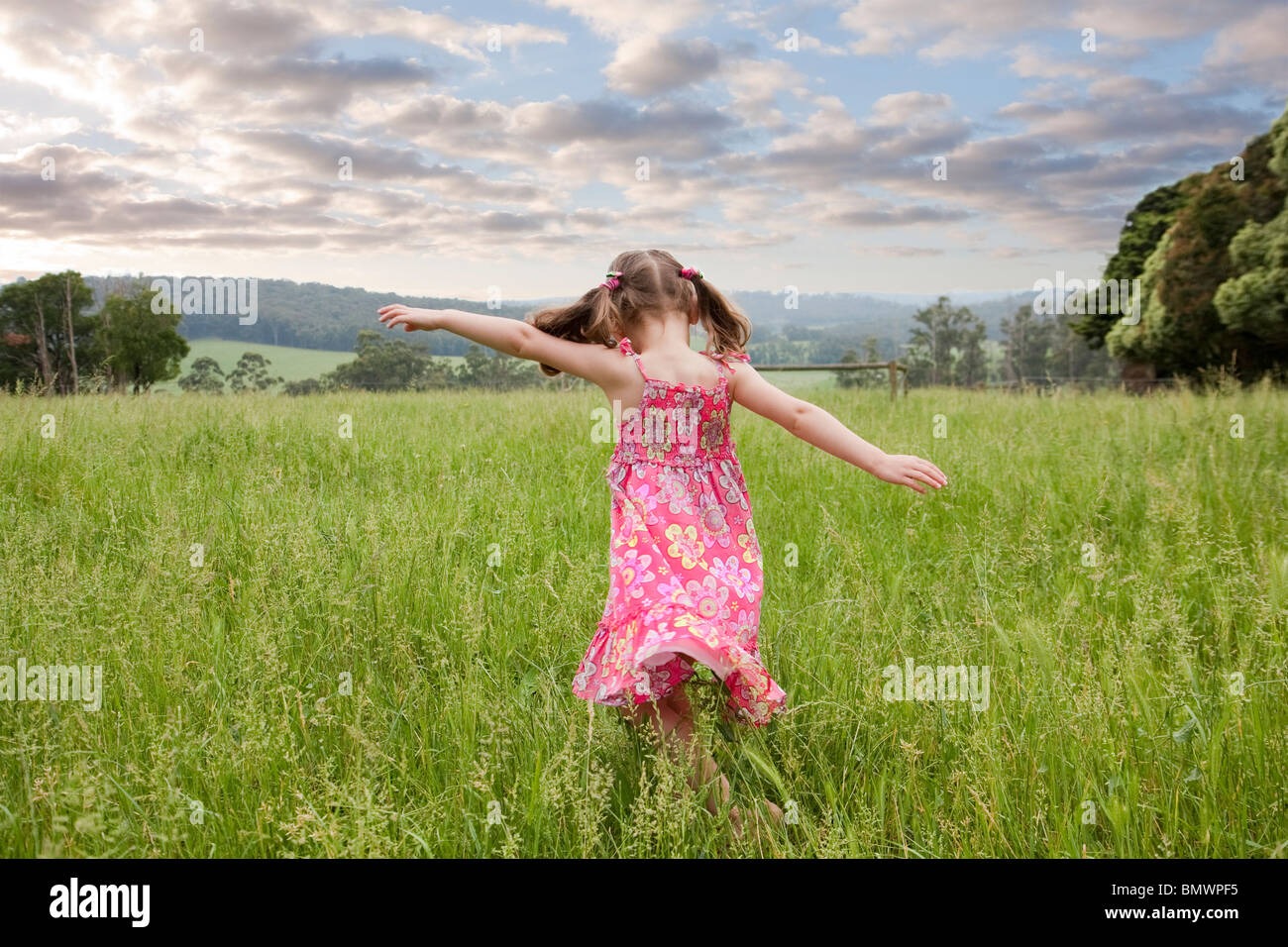 Girl running through long grass Stock Photo Alamy