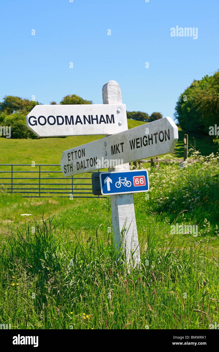 Traditional white signpost in the Yorkshire Wolds with blue cycle route