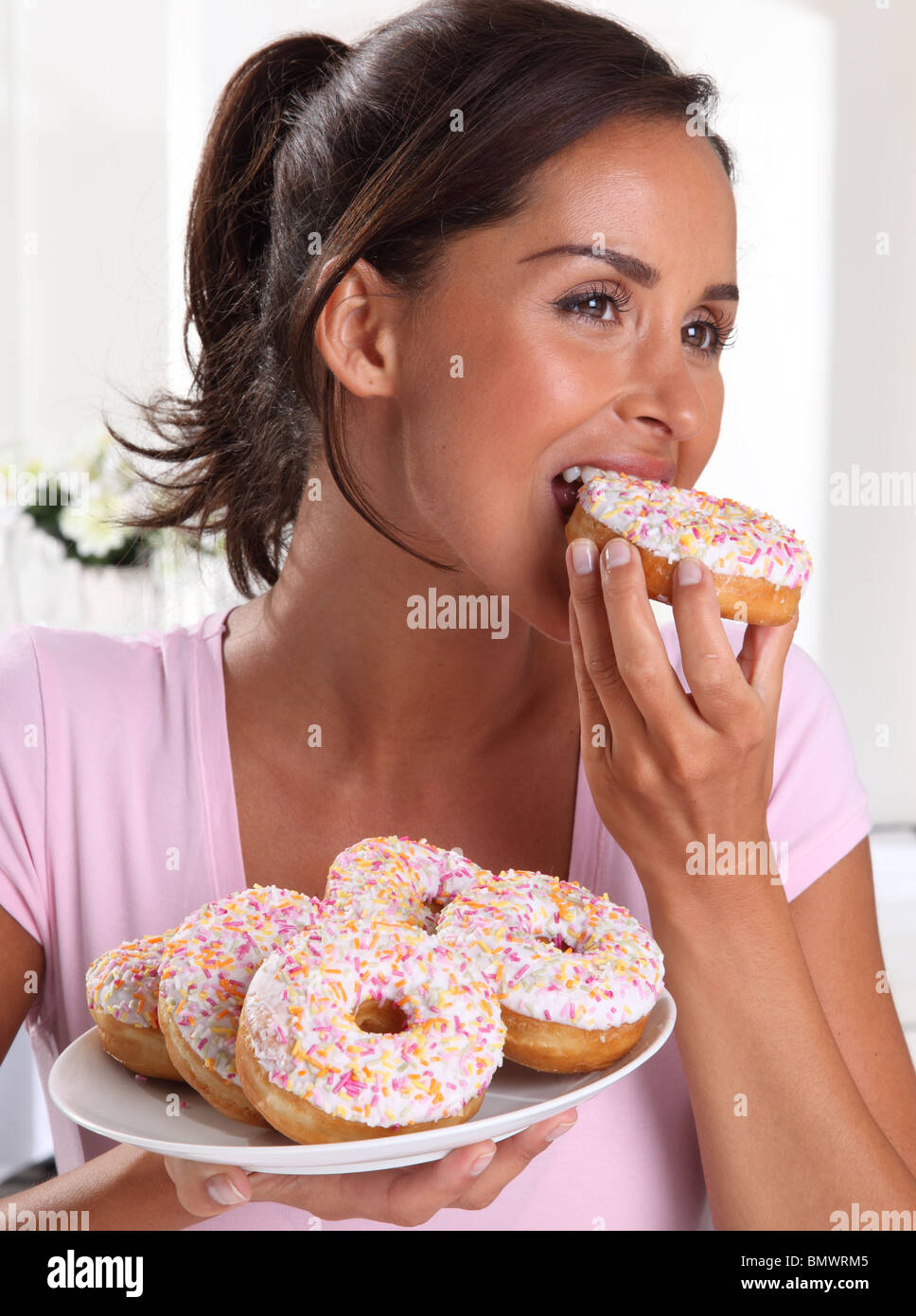 WOMAN EATING DOUGHNUTS Stock Photo