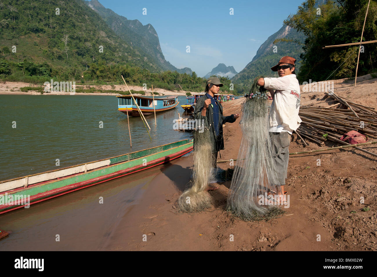 Fishermen arranging their nets on the banks of the Nam Ou river in Northern Laos Stock Photo