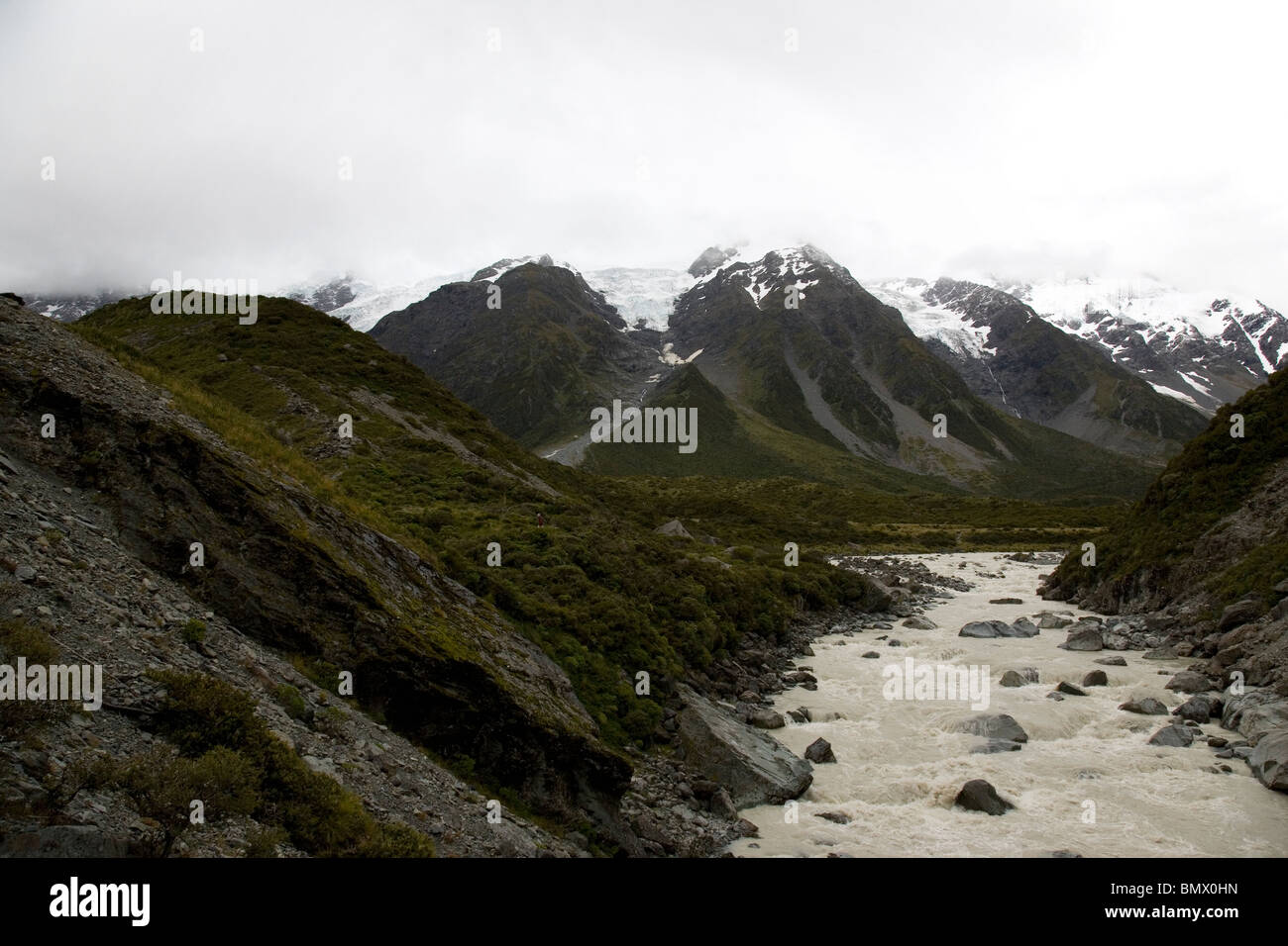 Cloudy day obscures Mount Cook peak as rain causes the hooker river to roar. Stock Photo