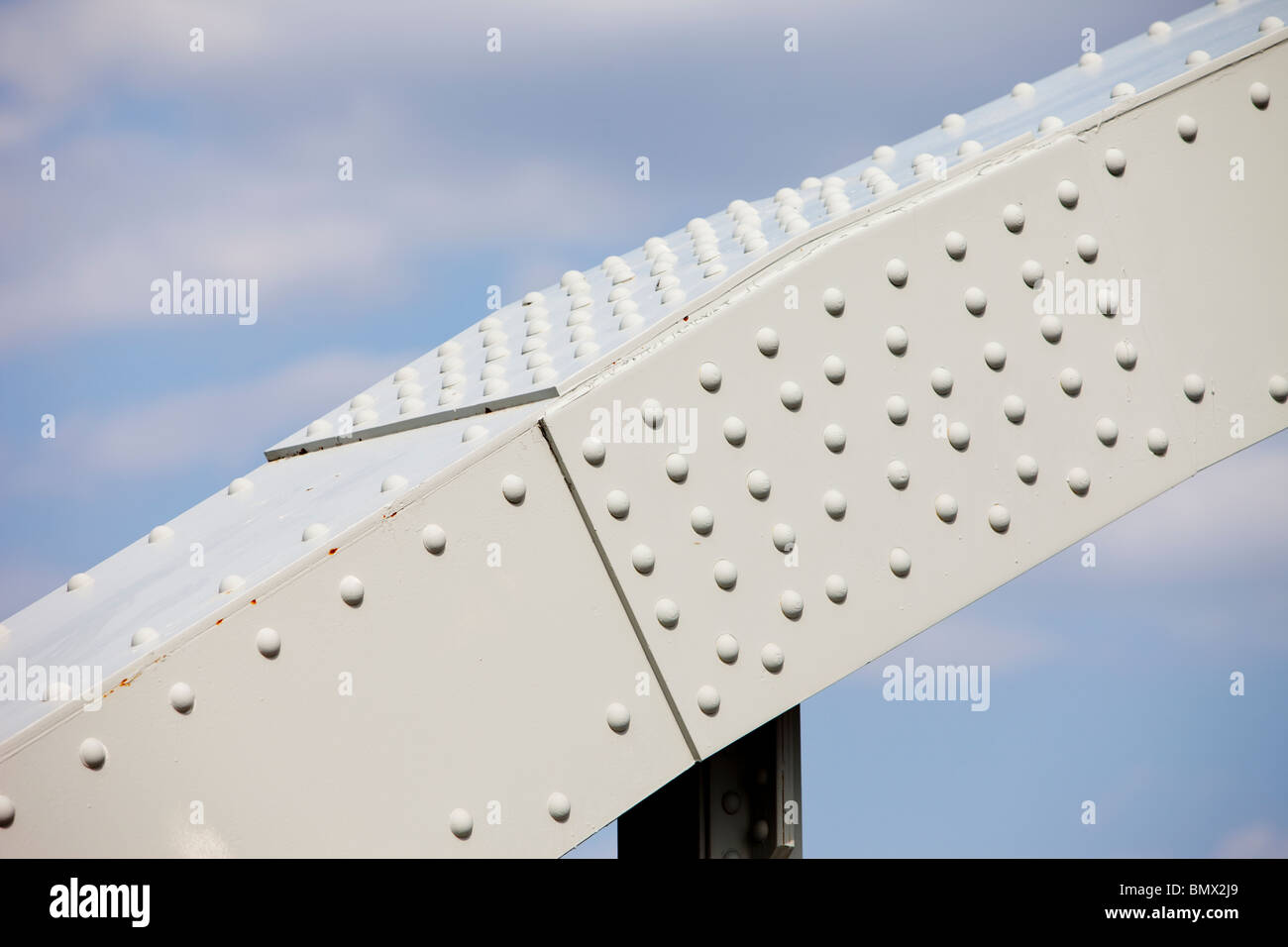 Steel beam joint made assembled using round rivets. Part of iron bridge support structure Stock Photo
