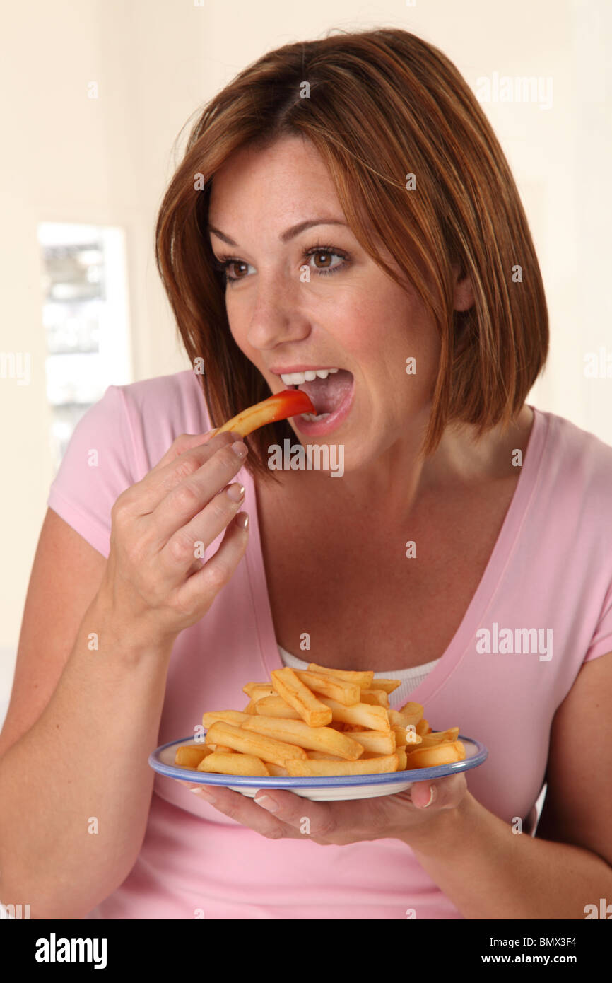 WOMAN EATING FRENCH FRIES Stock Photo