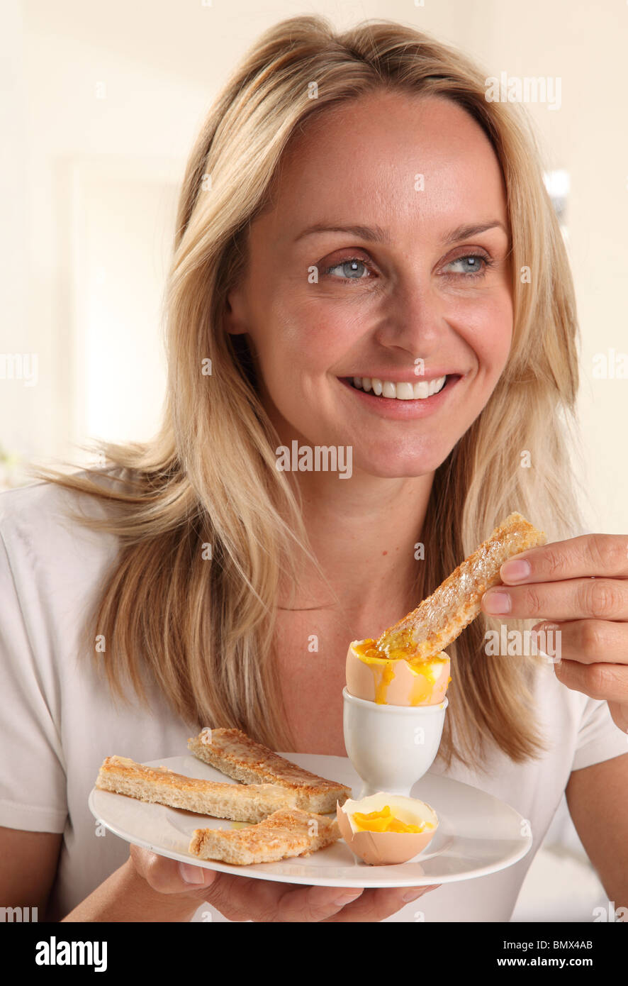 WOMAN EATING A BOILED EGG Stock Photo