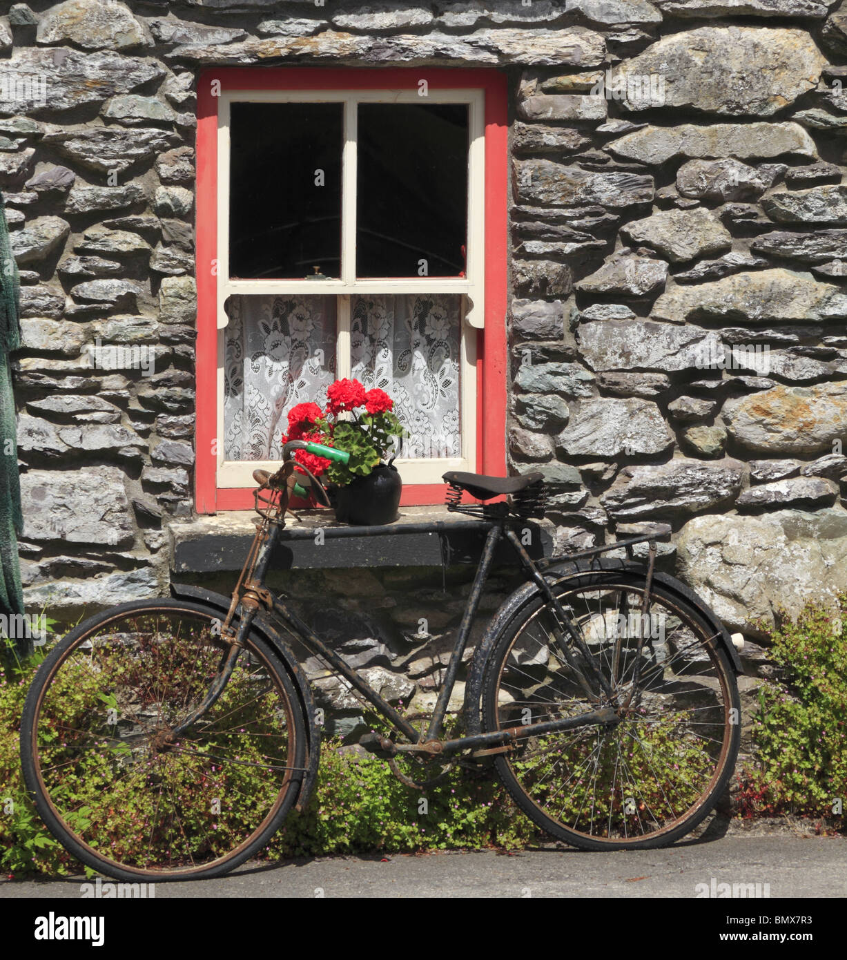 An old bicycle rests against the window ledge of traditional Irish farm cottage, Co Kerry, Republic of Ireland. Stock Photo
