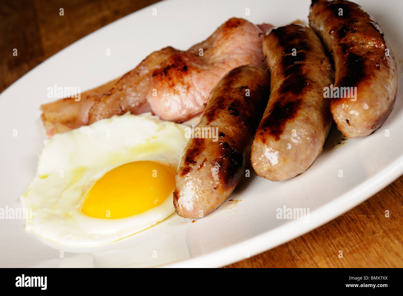 Stock photo of a traditional English Breakfast of sausages, fried eggs and bacon. Cholesterol