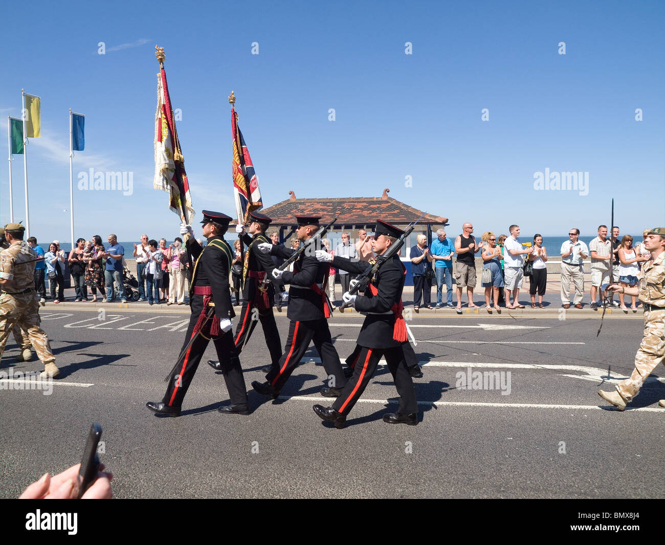 Standard bearers of the Yorkshire Regiment lead the trops marching