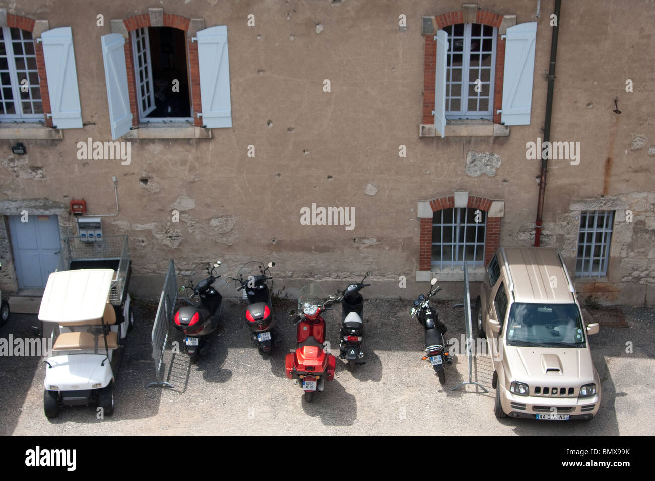 large chateau courtyard  windows cars motorbikes Stock Photo