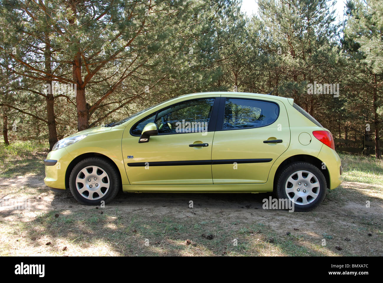 Peugeot 207 1.4 - 2009 (FL) - yellow metallic - three doors (3D) - French popular subcompact city car, seg. B - on meadow Stock Photo