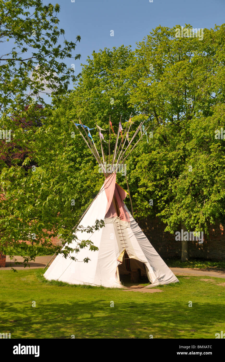 A Native American style tepee surrounded by trees. Stock Photo