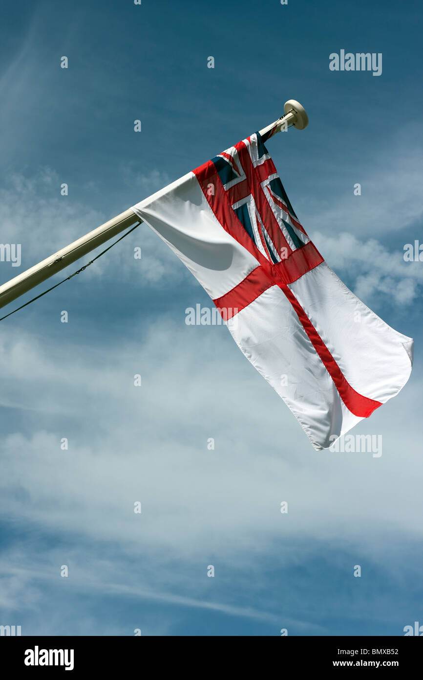 The British Navy white Ensign flying from Brunel's ship the ss Great Britain in Bristol. Shown against a blue sky with clouds. Stock Photo
