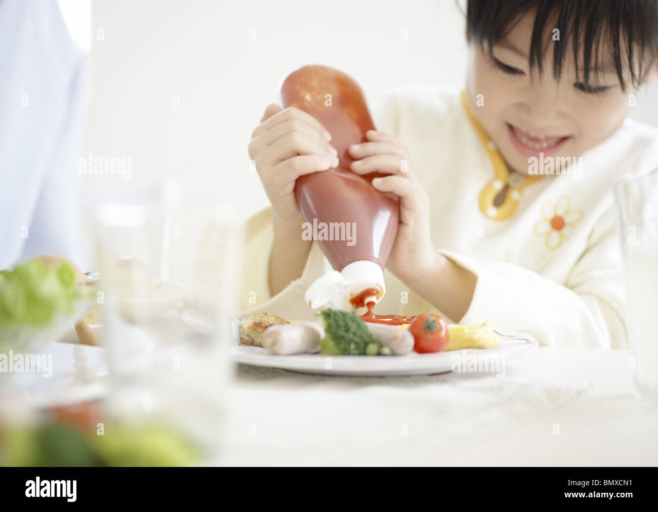 Girl putting ketchup Stock Photo Alamy
