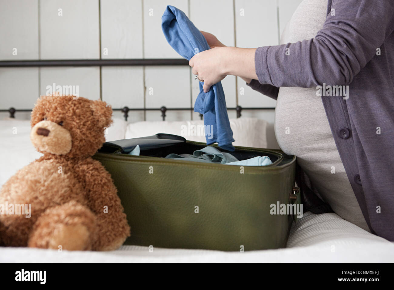 Expectant mother packing suitcase Stock Photo