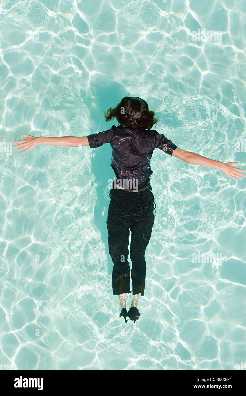 Woman face down in swimming pool Stock Photo