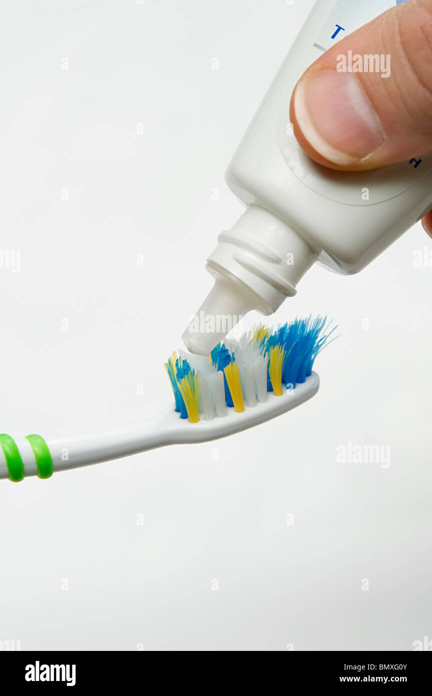 putting toothpaste on toothbrush