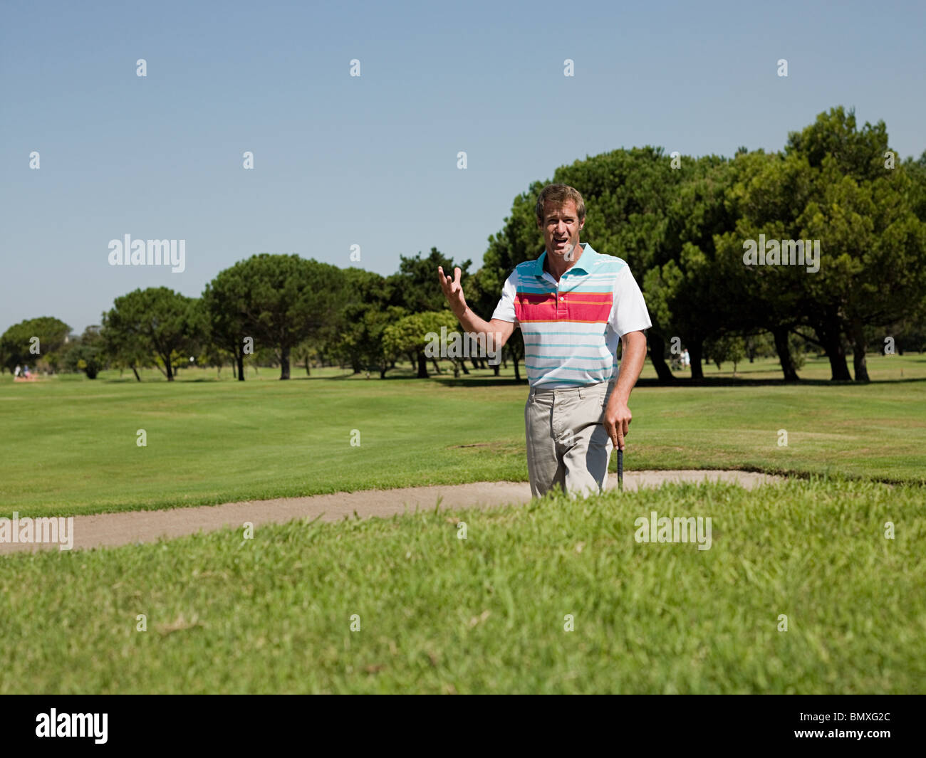 Man playing golf, stuck in bunker Stock Photo Alamy