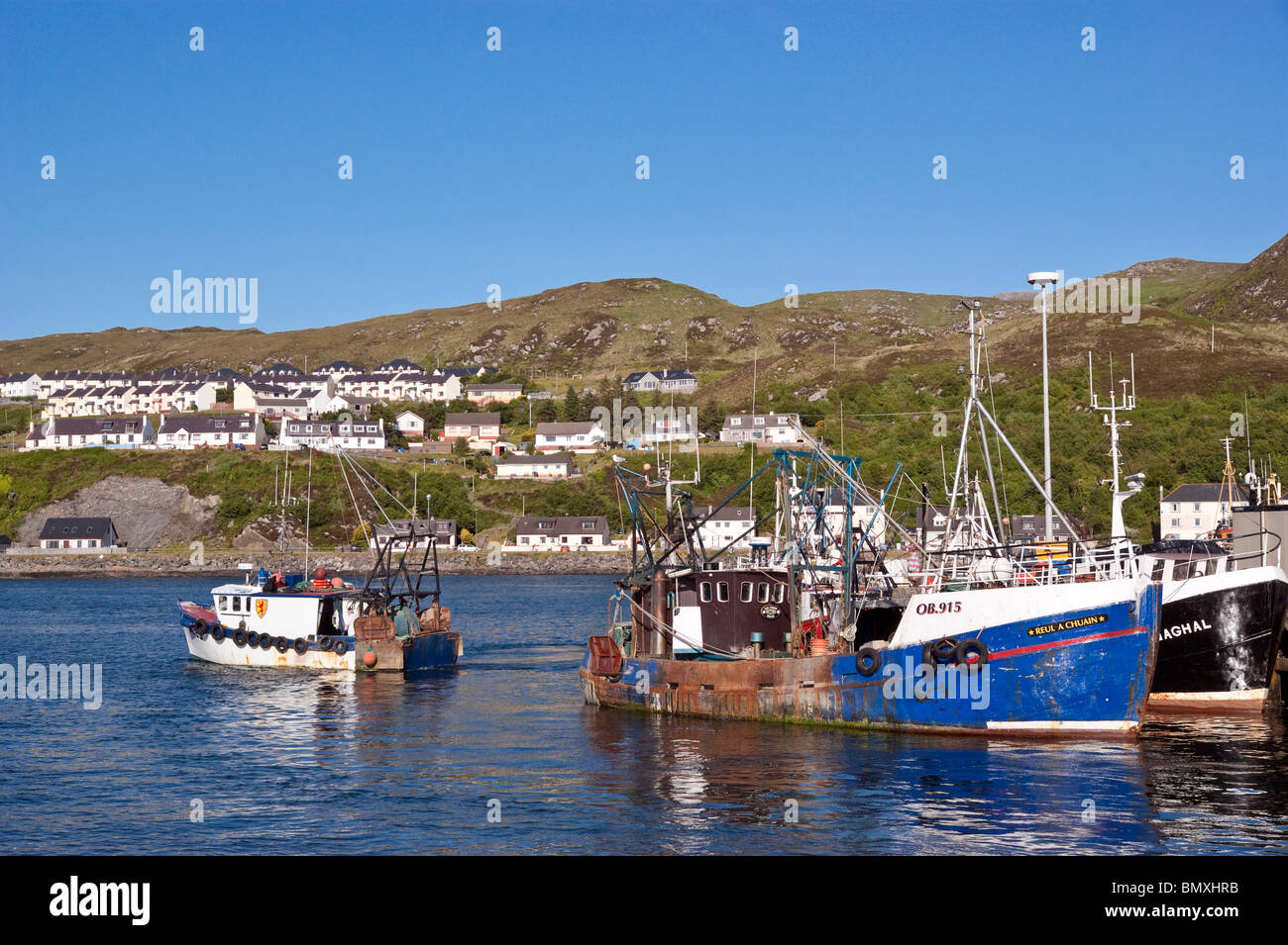 A fishing boat is leaving Mallaig Harbour in Mallaig West of Scotland Stock Photo