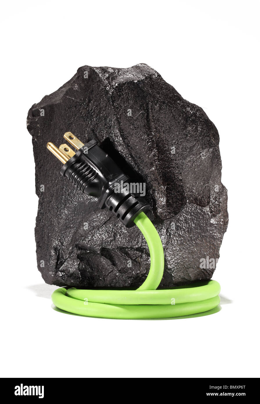 A large black piece of coal with a green electrical extension cord and plug wrapping around on a white background. Stock Photo