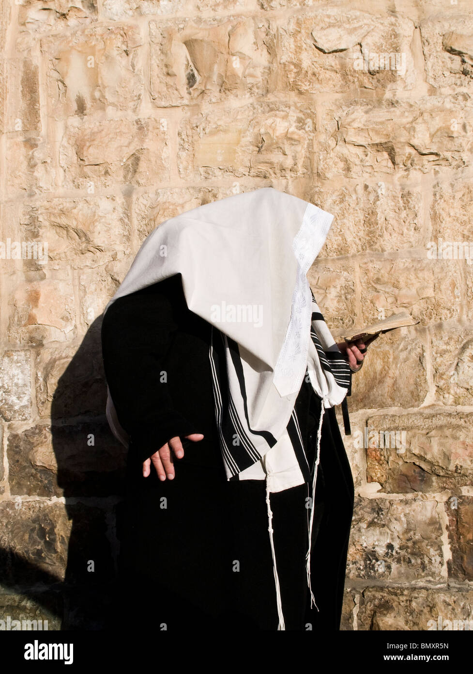 Reading the bible on his way to the wailing wall in Jerusalem Stock