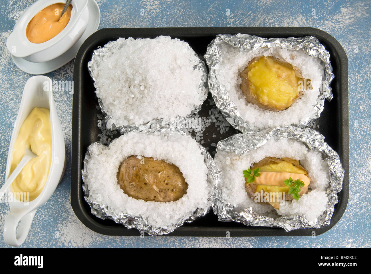 potatoes in salt crust and sauces Stock Photo