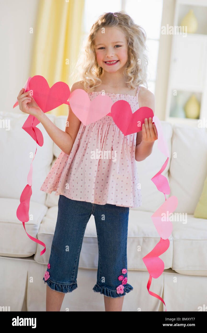 Young girl holding heart cut outs Stock Photo