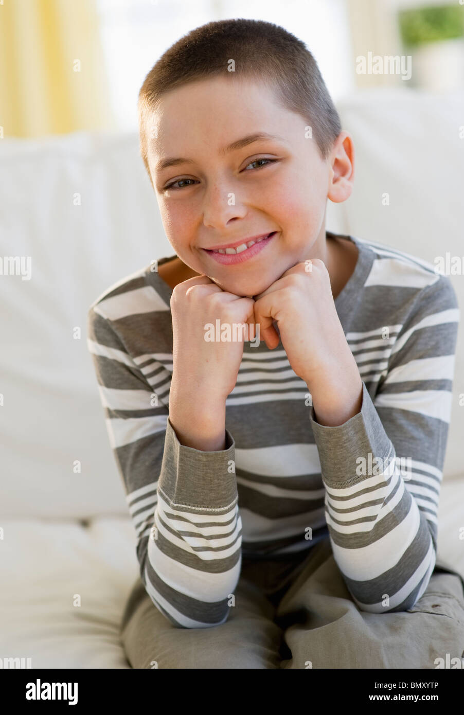 Young boy sitting on couch Stock Photo