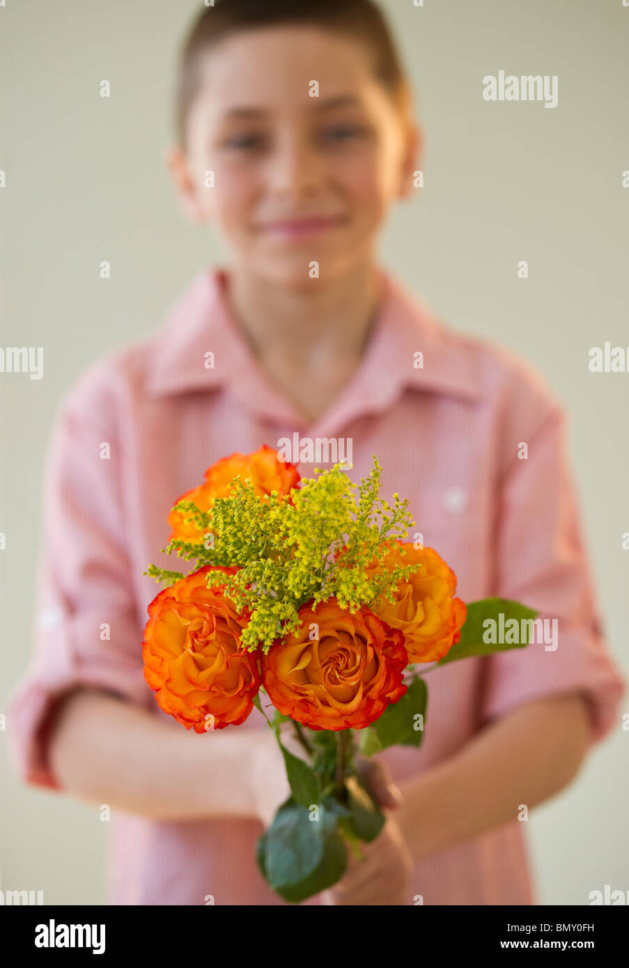 Young boy holding a bouquet of roses Stock Photo