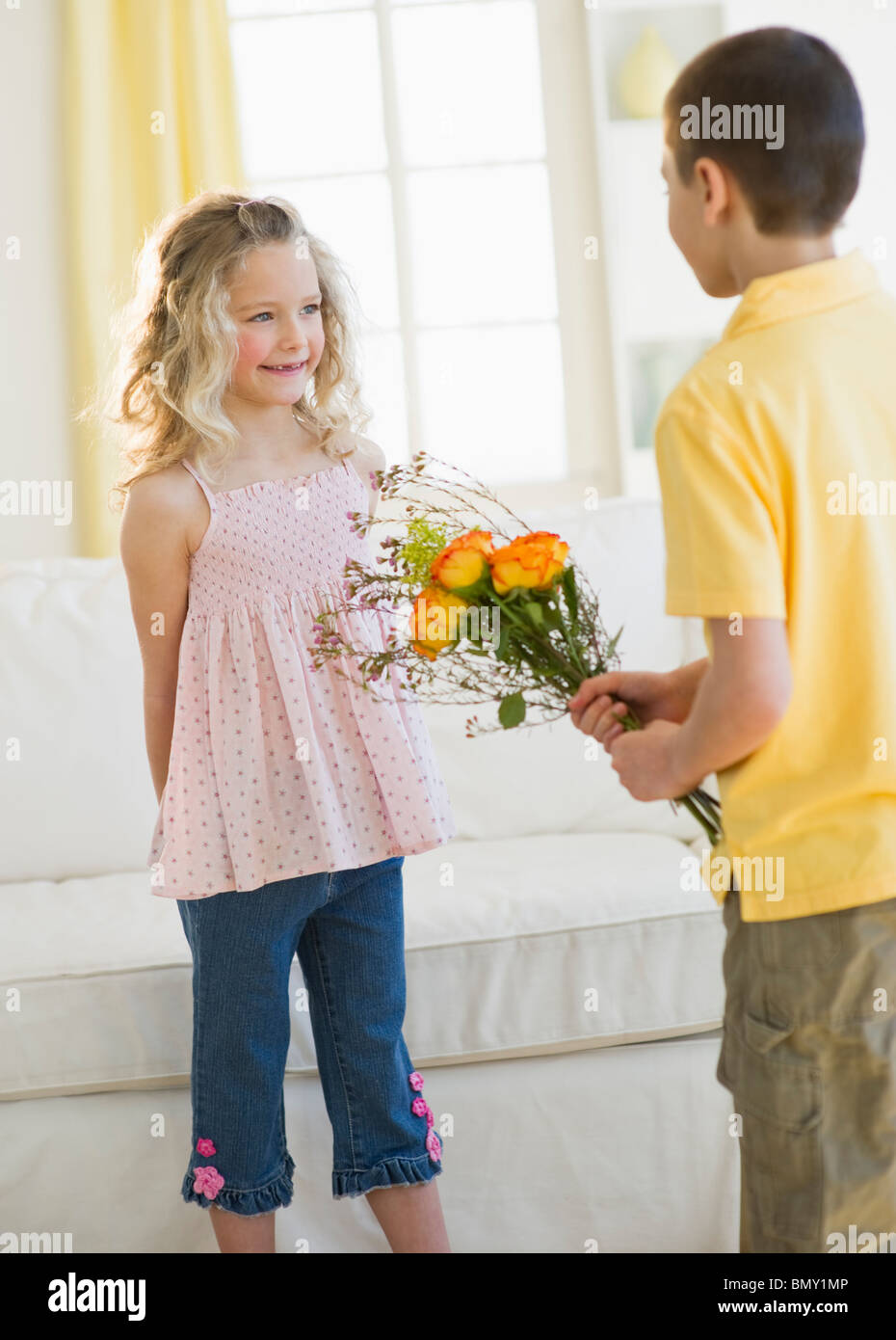 Young boy giving flowers to young girl Stock Photo