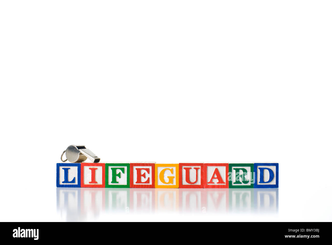 Colorful children's blocks spelling LIFEGUARD with a metal whistle Stock Photo