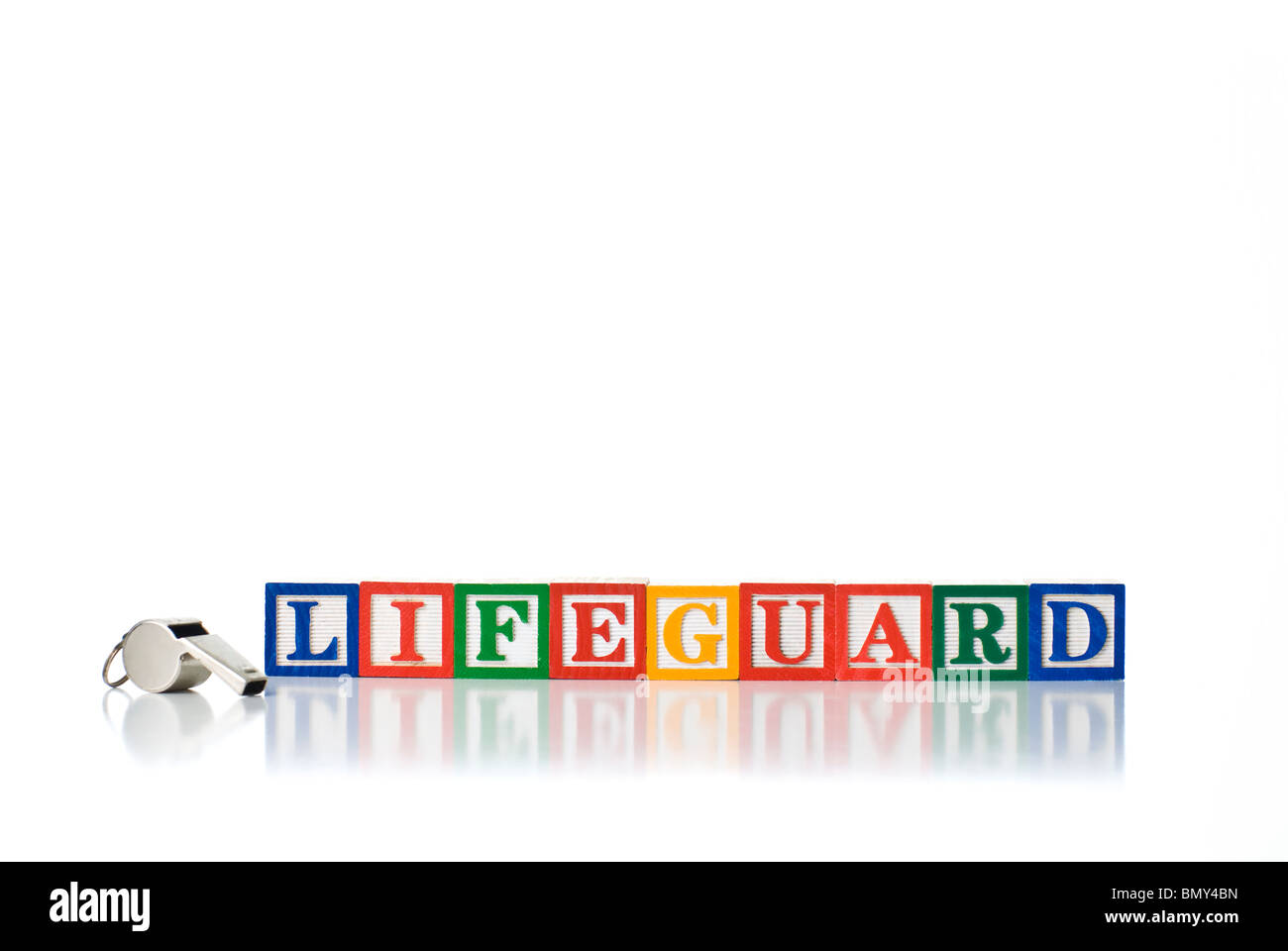 Colorful children's blocks spelling LIFEGUARD with a metal whistle Stock Photo