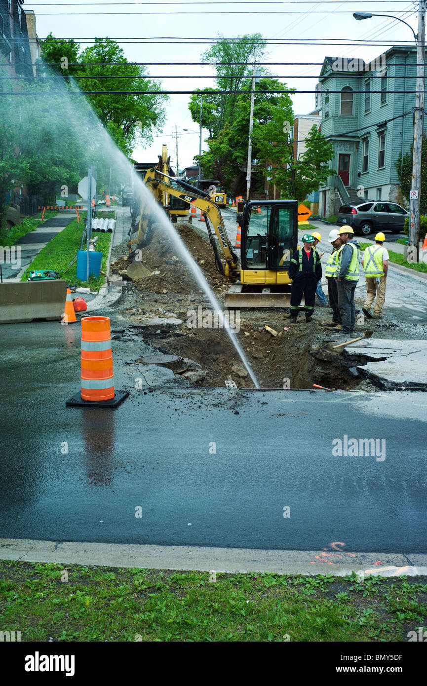 Road construction work on Barrington Street and Green Street. Broken water main sprays water. Stock Photo