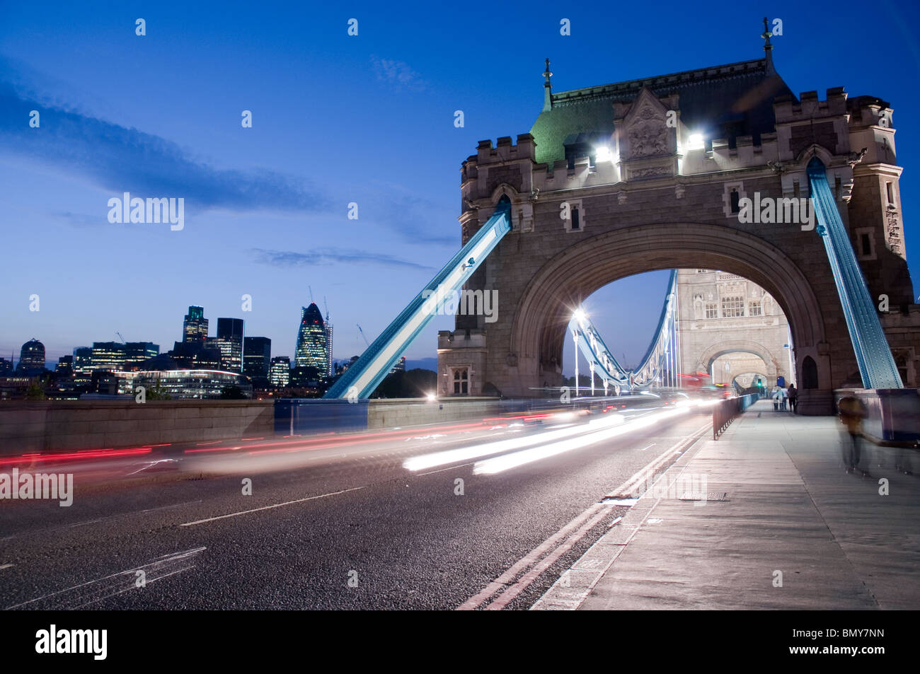 Detail of Tower Bridge in London at dusk with car light trail and city ...