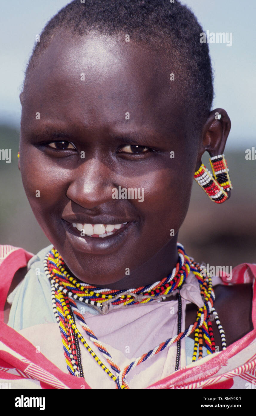 A Maasai girl decorates her stretched earlobes with colorful beads, the favorite ornament of her tribe in Kenya, East Africa. Stock Photo