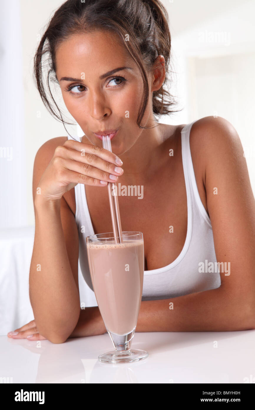 WOMAN DRINKING CHOCOLATE MILKSHAKE OR SMOOTHIE Stock Photo