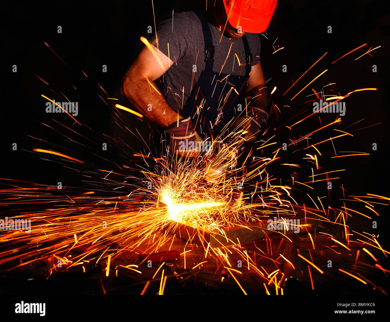 labor aty work with electric grinder, industrial background Stock Photo